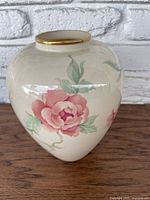 View of the Lennox Chadworth vase showing red rose flowers and green leaves on a cream background with gold rim detail.