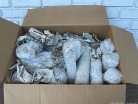 View of the open box showing multiple pieces of glassware wrapped in bubble wrap and newspaper inside a cardboard box.
