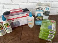 Photo of entire lot showing 3M first aid kit, bottles of mosquito repellent sprays, Thermacell Patio Shield lantern boxed, and repellent refill boxes stacked.