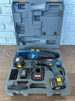 Ryobi cordless drill, vacuum, charger, batteries inside fitted plastic carrying case showing layout and condition.