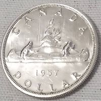 Obverse side showing the date 1957 with two figures paddling a canoe and the text 'CANADA DOLLAR'.