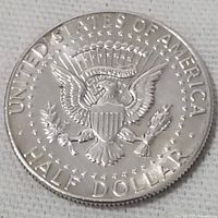 Close-up photo of the reverse of the 1969 Kennedy half dollar coin showing the Presidential Seal and inscriptions.