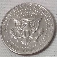 Reverse side of the 1971 USA half dollar coin showing the heraldic eagle and inscriptions.