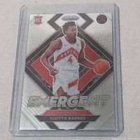 Scottie Barnes rookie basketball card in protective sleeve, showing front design with player in Raptors uniform, Emergent series.