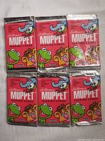 Six sealed unopened packs of 1993 Jim Henson's Muppet Trading Cards laid flat showing front packaging with characters Kermit, Fozzie Bear, Gonzo