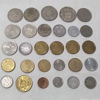 Top view of laid out mixed international coins showing different sizes and designs