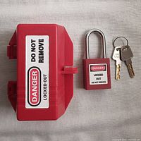 Red electrical plug lockout box with warning label, red padlock, and two keys on keyring