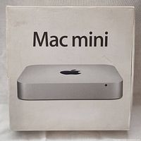 White retail box with “Mac mini” text and product image; box shows creases and light wear