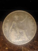 Reverse view of the 1917 British one penny coin showing Britannia seated with trident and denomination details.