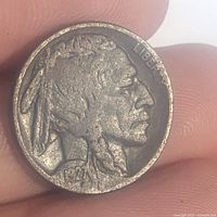 Close-up of the obverse of the 1927 Indian Head Nickel showing Native American profile, wear, and dark toning.