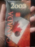 Sealed black and red packaging featuring bear silhouette and Canada text with year 2003 on it