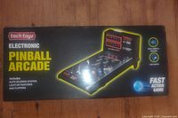 Box and packaging of Tech Toyz Electronic Pinball Arcade tabletop game, showing branding, feature highlights, and box condition.