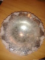 Top-down photo showing ornate grape vine pattern and scalloped edges with cutout detailing.