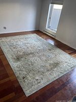 Rug laid out on hardwood floor near window