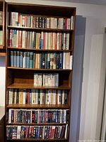 Books filled on a tall wooden bookshelf with multiple shelves
