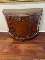 Front view of half moon credenza showing carved details