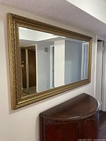 Full view of mirror mounted above a wooden console table
