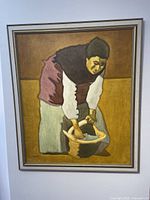 Frontal view of the framed oil painting showing woman washing clothes in basket.