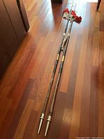 Two full-length RCMP spears side by side on hardwood floor