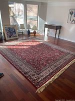 Rug laid flat on hardwood floor showing overall pattern, border, and fringe