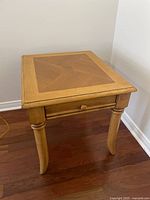 Side angle view of the wooden square side table showing legs and drawer.