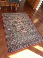 Full view of the 5x7 multicolor traditional area rug laid on a hardwood floor, showing the overall size and pattern.
