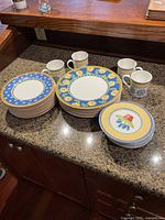Overview of plates and mugs arranged on countertop showing design patterns and quantity