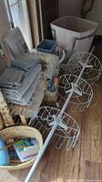 View of towels, laundry baskets, basket with toiletries, white plastic organizer, and two white multi-tier hanging organizer racks