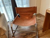 Full side view of the chair showing its chrome frame and canvas seat.