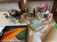 Photo showing assorted animal figurines, decorative tray, pottery sun plaque, brass items, glass pieces, and ceramic wall vase.