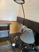 Floor lamp with black resin base and circular LED light, two table lamps, several power bars and cords all together.