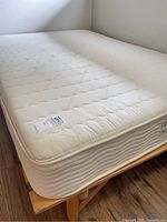 Mattress set up on wood slat base, showing overall condition
