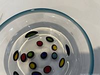 Top view showing colorful circular accents and robin's egg blue rim of the clear glass bowl