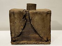 Front view of rectangular vase with textured surface and staircase-like design detail.