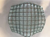 Top view of seagreen fused glass vessel showing grid wire imprints and curved rectangular shape.