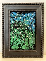 Full view of the framed textile artwork showing colorful threads and embedded pearls in a black ornate frame.