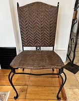 Front view of one steel chair showing woven leather seat and back with curved legs