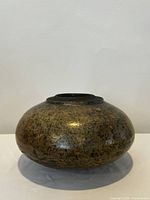 Front view of vintage pottery vase showing round bulbous shape and speckled glaze.