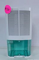 Front view of compact white dehumidifier with horizontal slats and translucent green water tank below