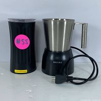 Milk frother and coffee warmer set shown from the front with electric cords.