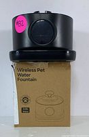 Black wireless pet water fountain placed on its original packaging showing front view with label indicating 2.8L capacity.