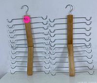 Two wooden multi-layer pants hangers standing upright, showing 10 metal horizontal rods for hanging pants or ties each, wooden center with metal hooks.