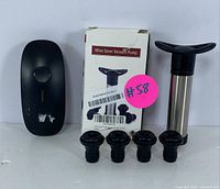 Electric wine opener alongside wine saver vacuum pump, four airtight stoppers, and the pump's original box.