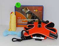 Photo showing XL light-up dog harness with reflective straps, adjustable buckles, and included USB charging cable, alongside the box with an image of a dog wearing the harness, plus the yellow chew toy and blue fetch toy.