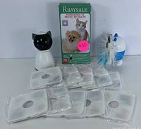 Pet water fountain filters and cat toy dispensers displayed with packaging and feather attachments.