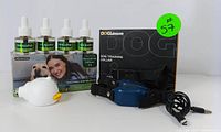 Photo of dog training collar with remote and calming pheromone diffuser kit including four refill bottles and packaging.