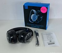 Gaming headset with box, detachable microphone, and instruction manual displayed on table.