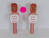 Front view of two pink wireless Bluetooth karaoke microphones showing control panel with buttons and speaker area, with a pink sticker #40.