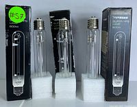 Four Vivosun 600W Super HPS grow lamps displayed upright on foam bases with three packaging boxes visible behind, showing black packaging with white text and technical illustration of the bulb.