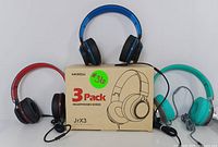 Three wired headphones (red, blue, teal) displayed with the original MIXCU JrX3 cardboard packaging.